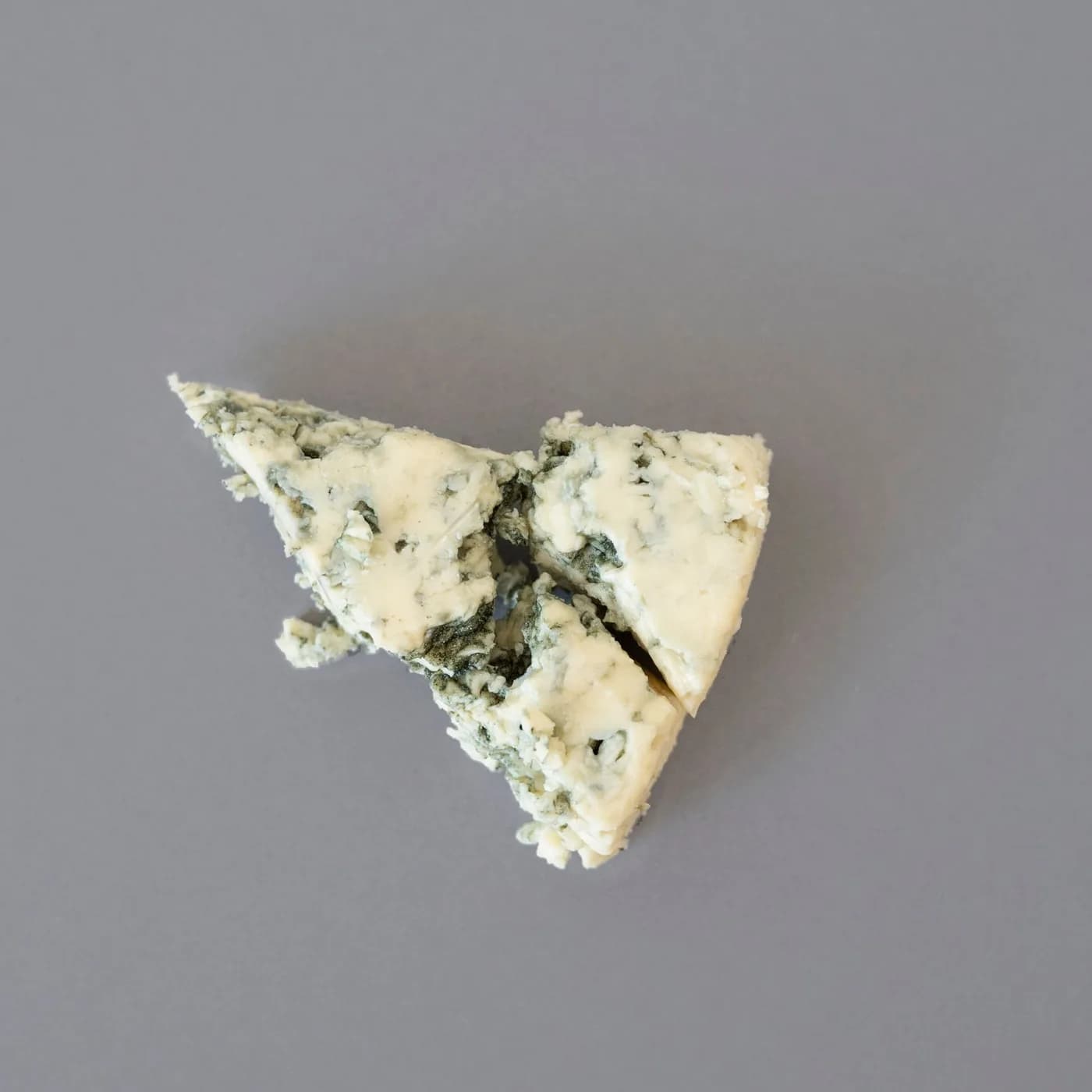 Cunha de queijo gorgonzola, com os veios azuis característicos à mostra